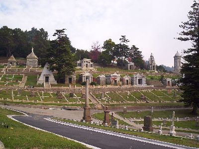 a well manicured lawn is spotted with gravestones of many shapes, sizes, and materials at mountain view cemetery. some are large enough to be small buildings