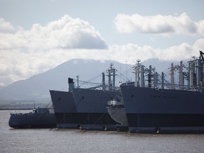 several large ships are anchored close together in suisun bay, members of the ghost fleet.